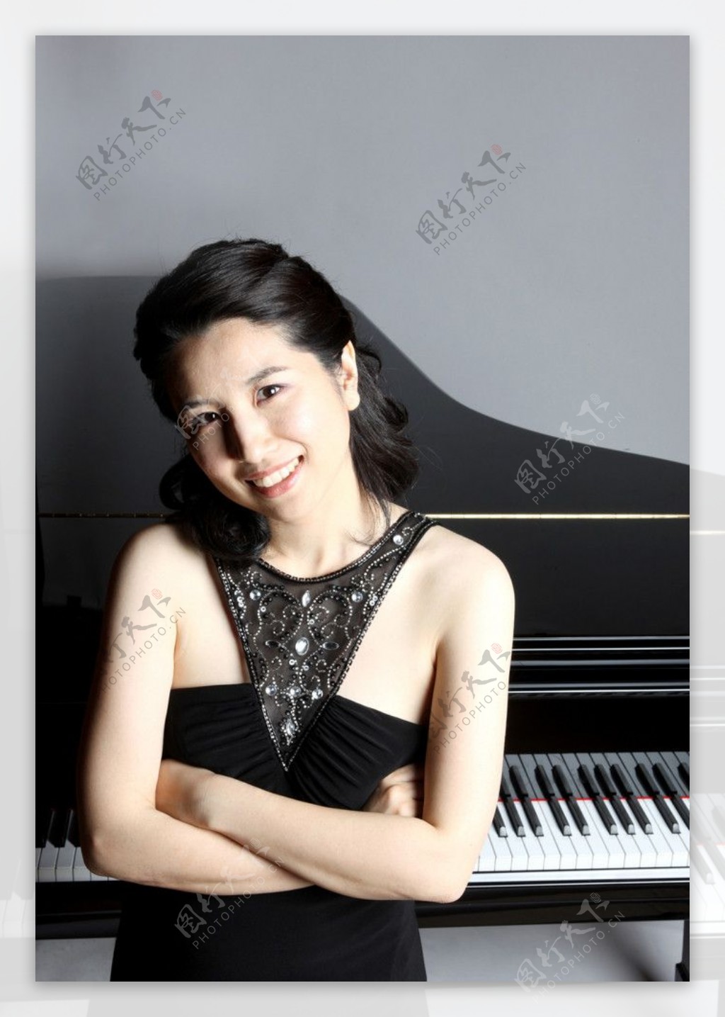 美丽微笑穿黑色晚礼服的女钢琴家图片