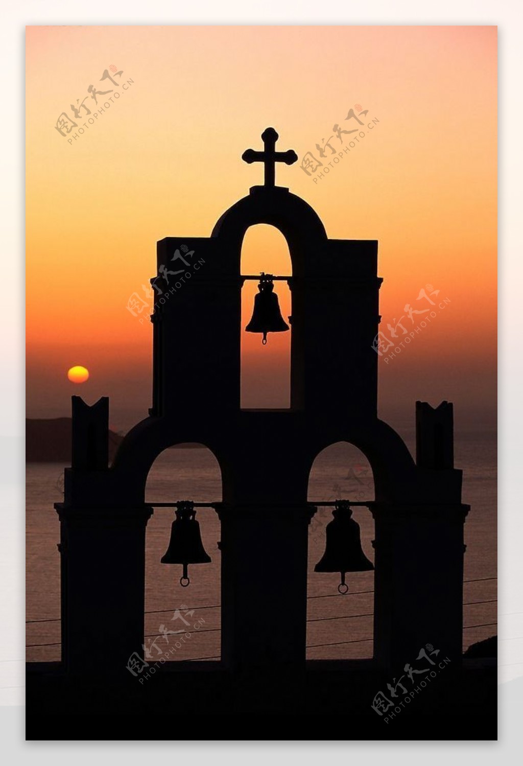欧洲海岸的夕阳下的十字架钟声图片