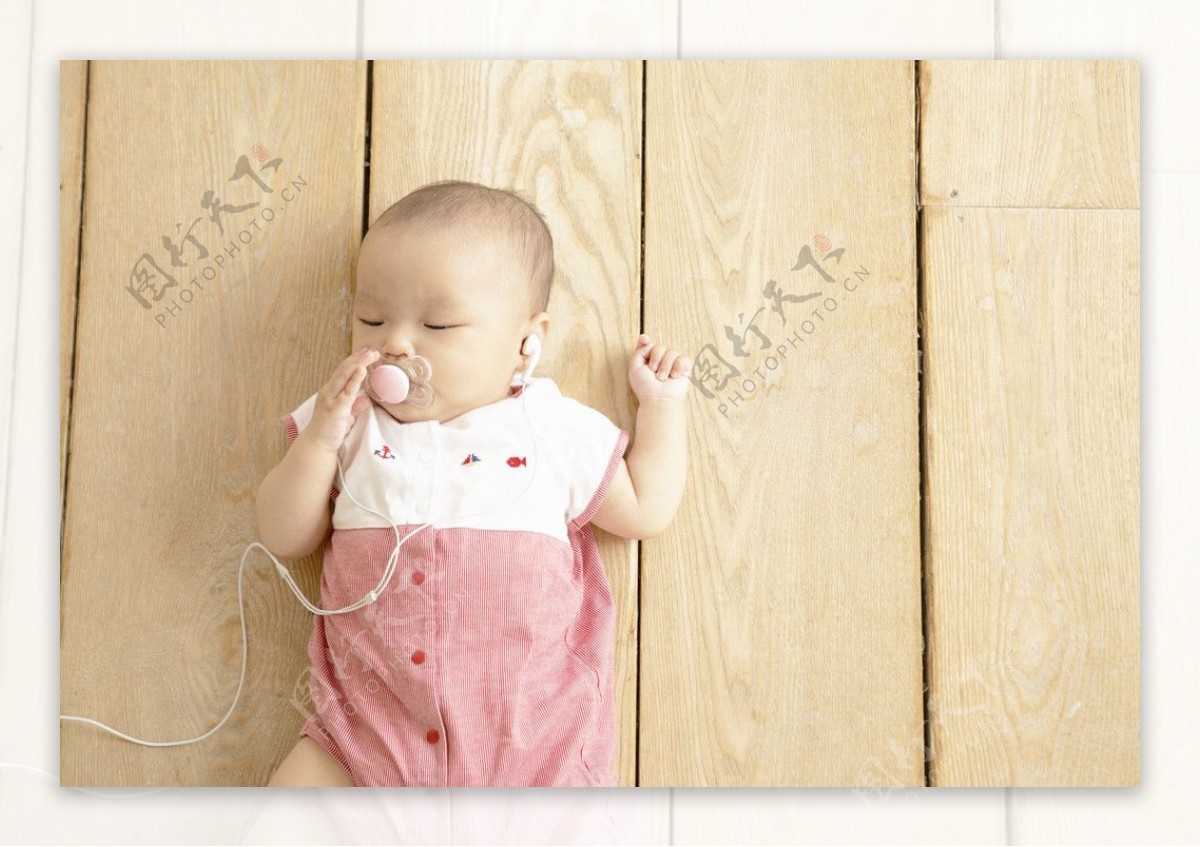躺在木纹地板上听音乐的婴儿宝宝图片