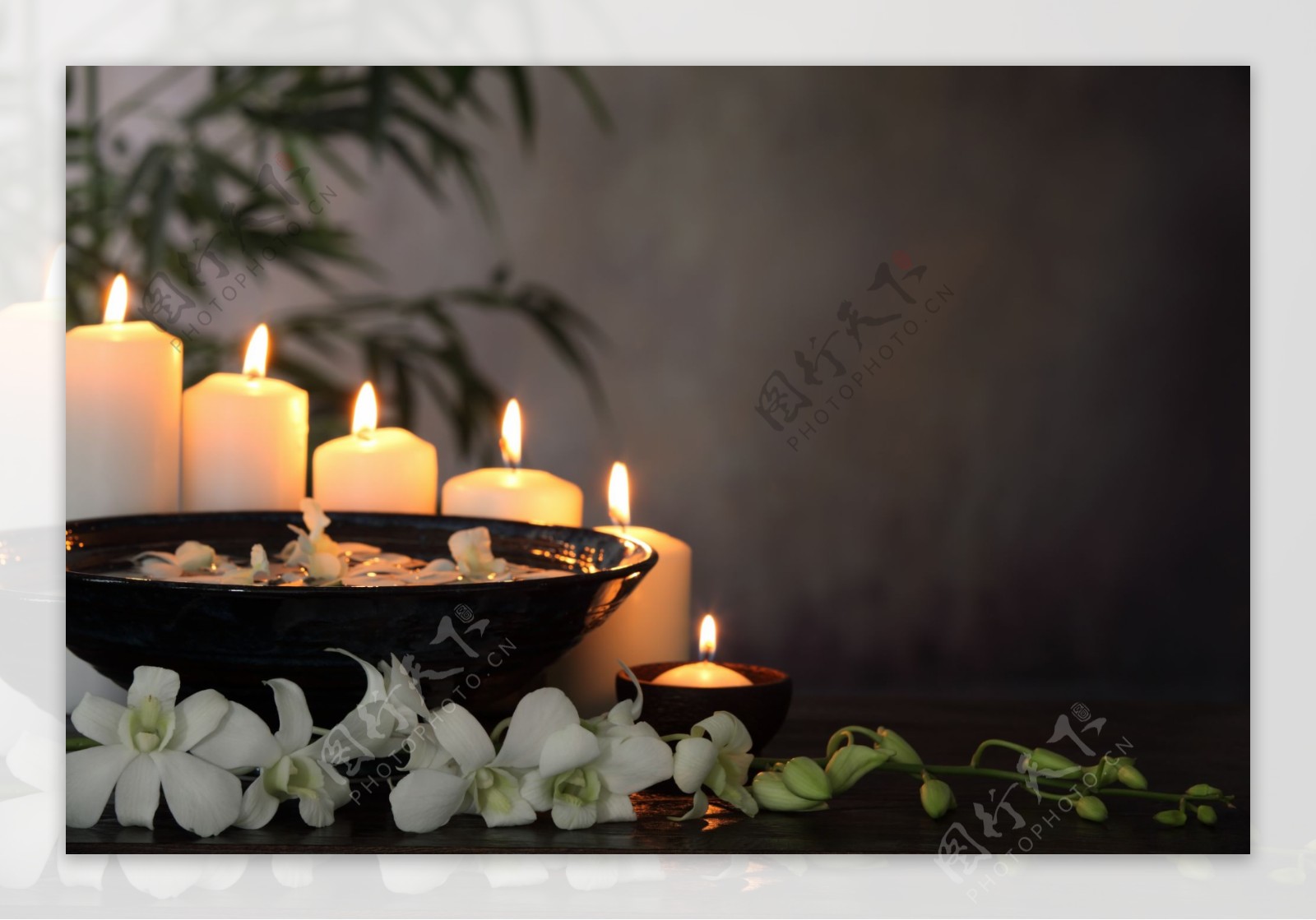 整齐的蜡烛和盘子以及花朵图片