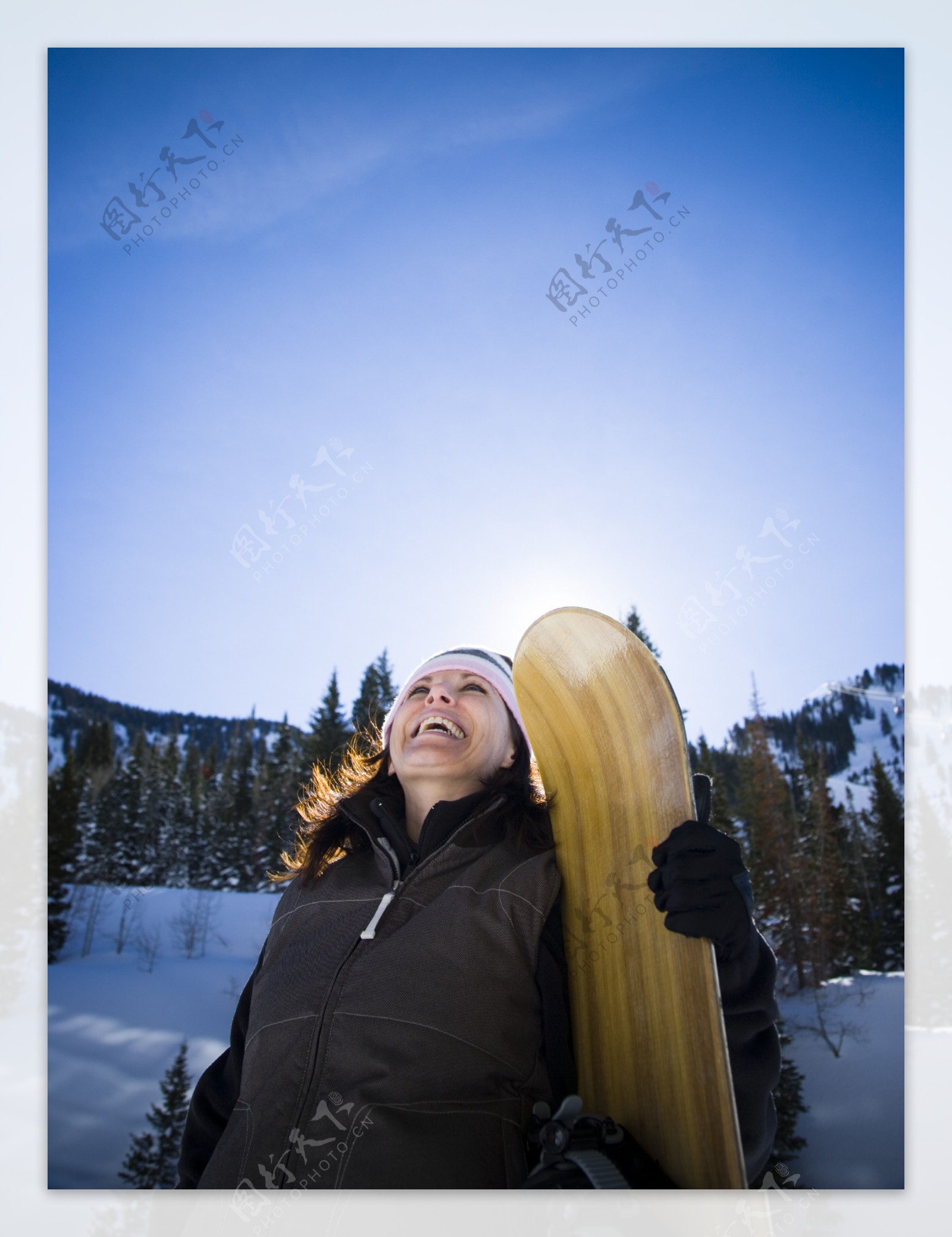 手拿滑雪板灿烂微笑的女性图片