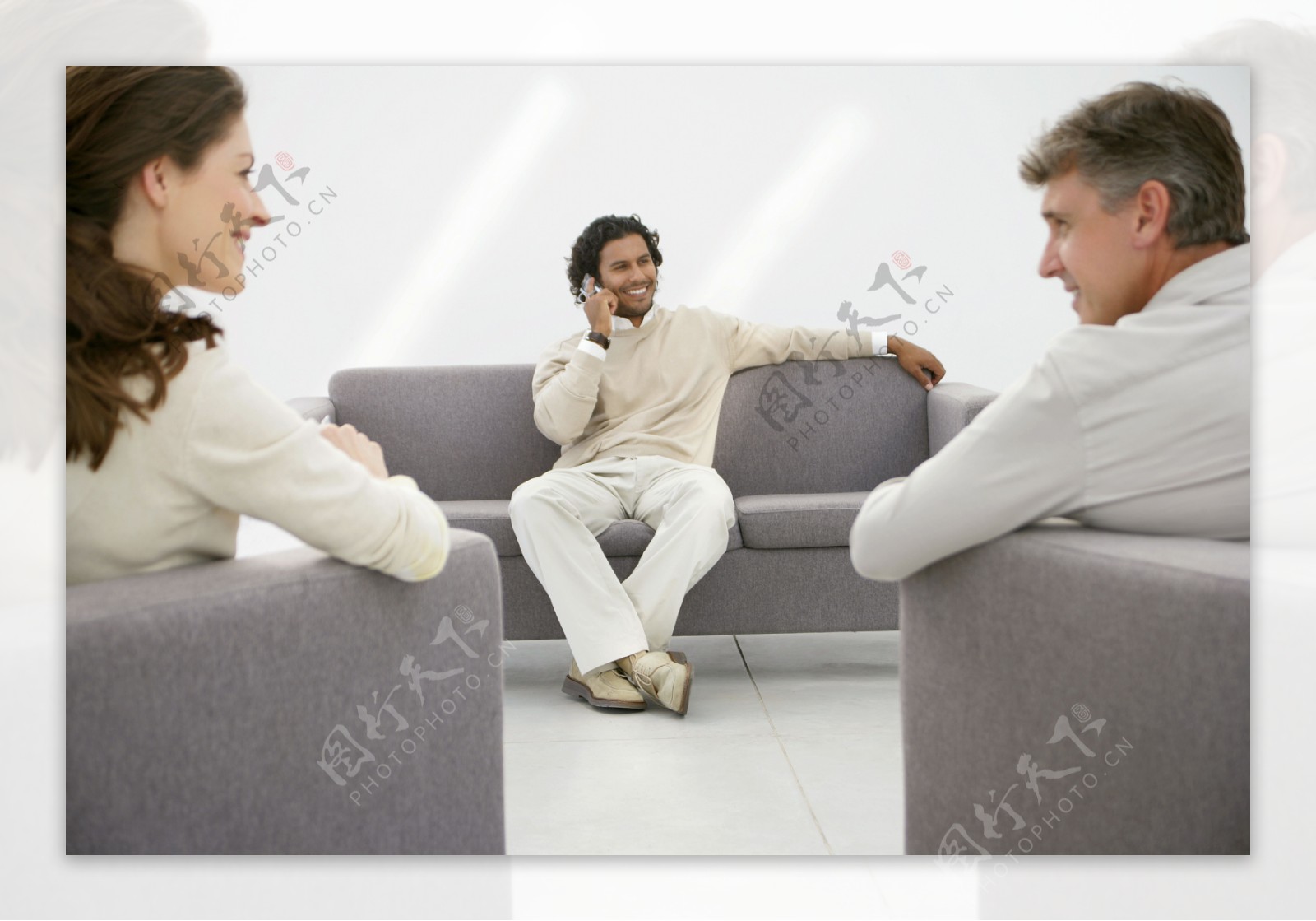坐在灰色沙发上的三个商务人士图片