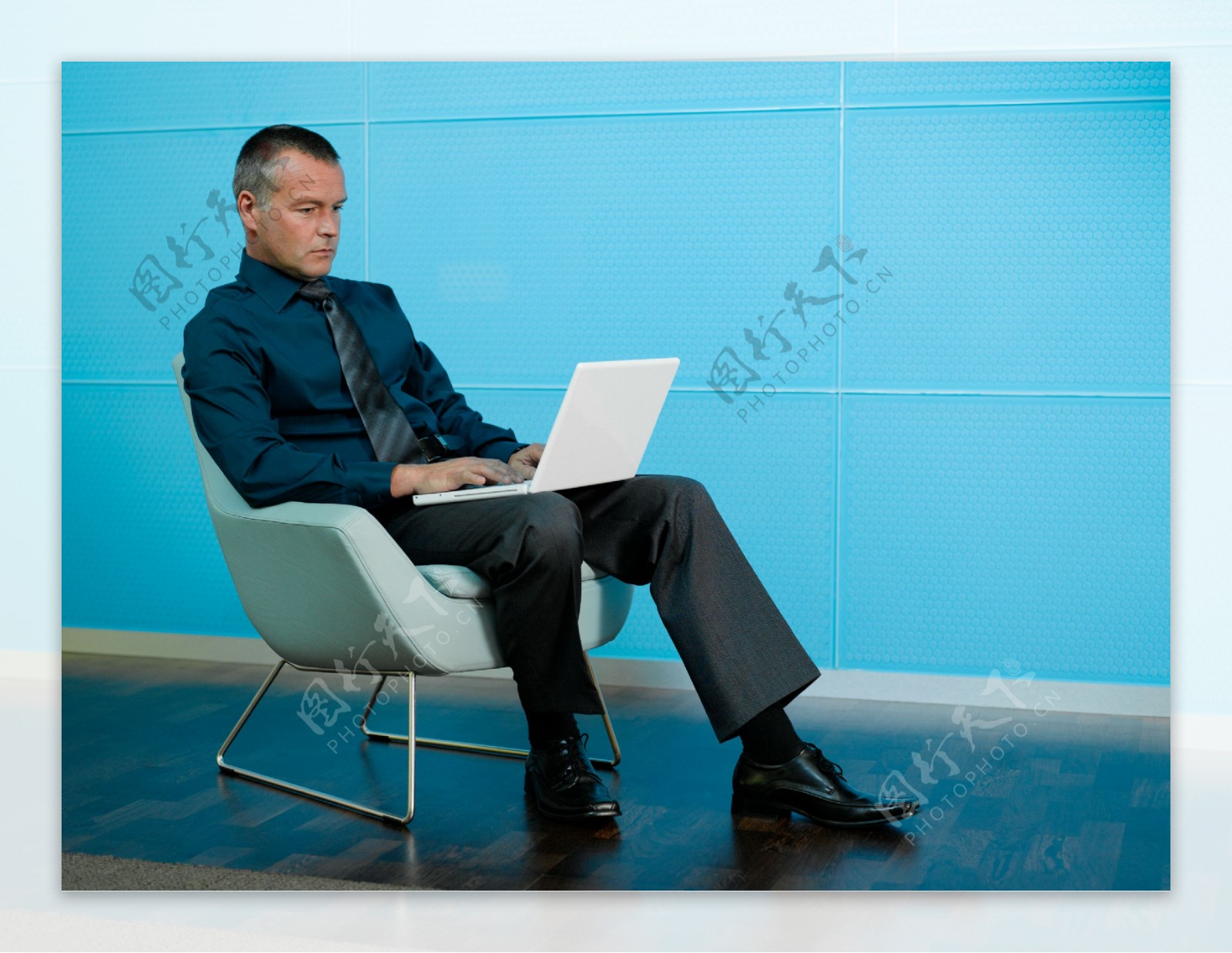 坐在椅子上玩电脑的男人图片