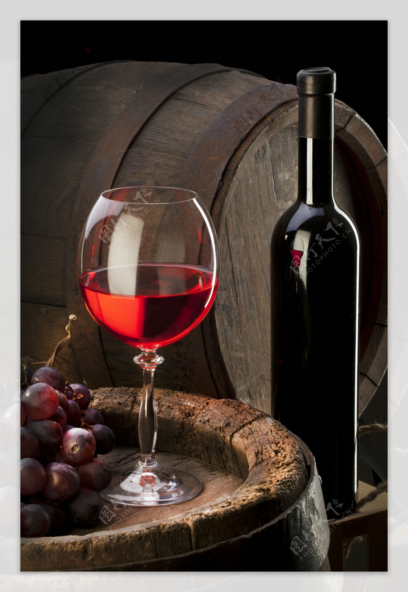 酒桶上的红酒和葡萄图片