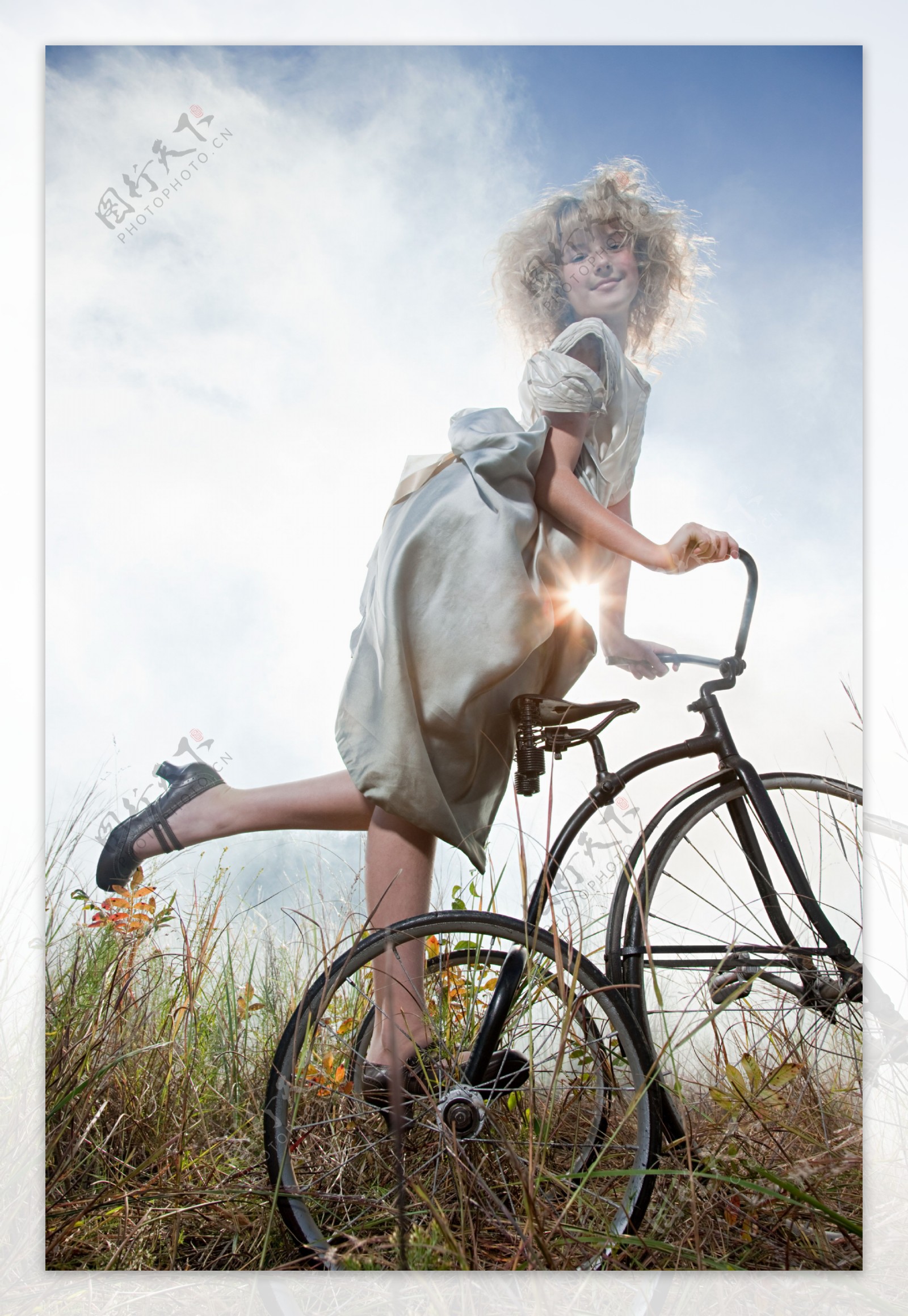 草丛中骑自行车的小女孩图片
