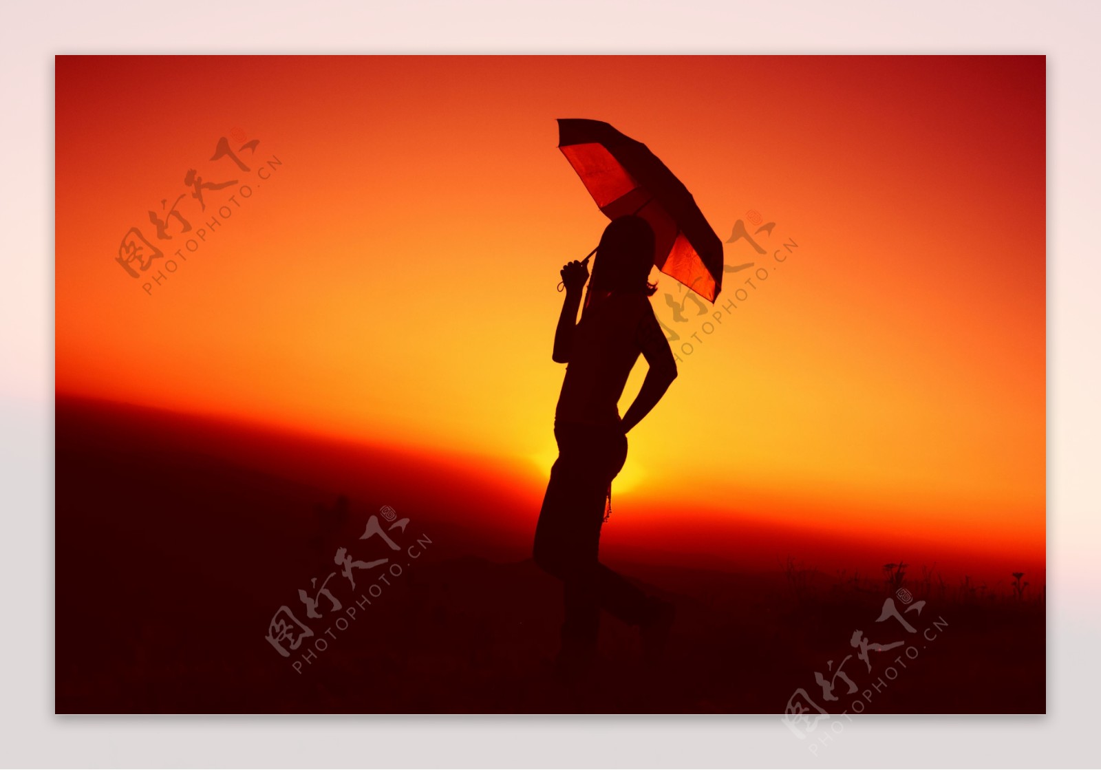 黄昏时打雨伞的美女图片