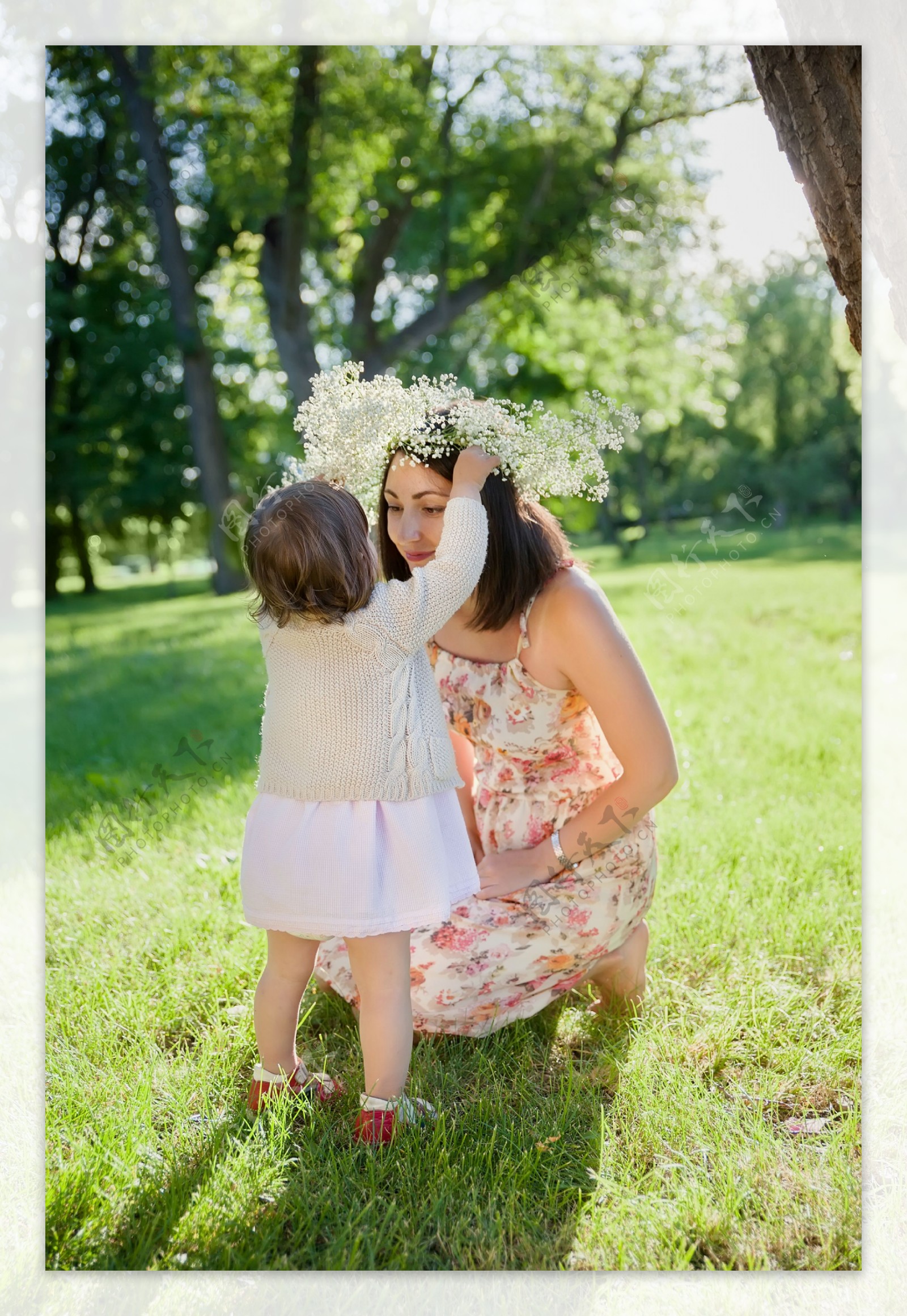 草地上在妈妈戴花环的小女孩图片