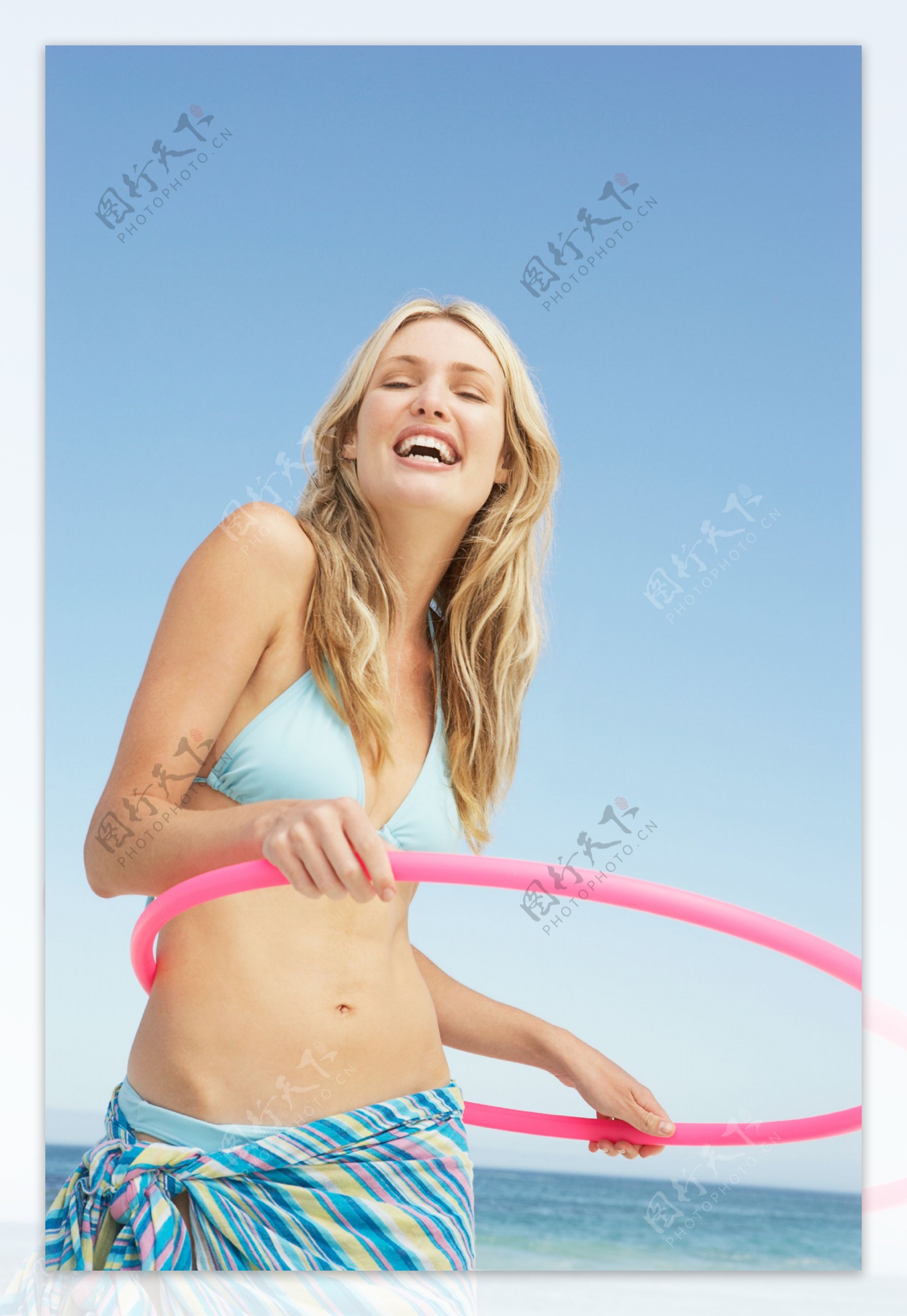 沙滩上玩呼拉圈的性感美女图片