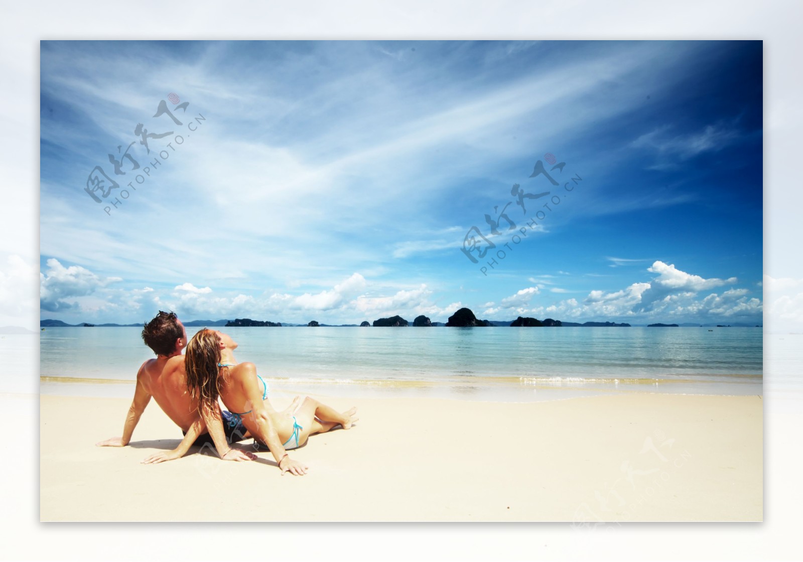 坐在海边沙滩上的情侣图片