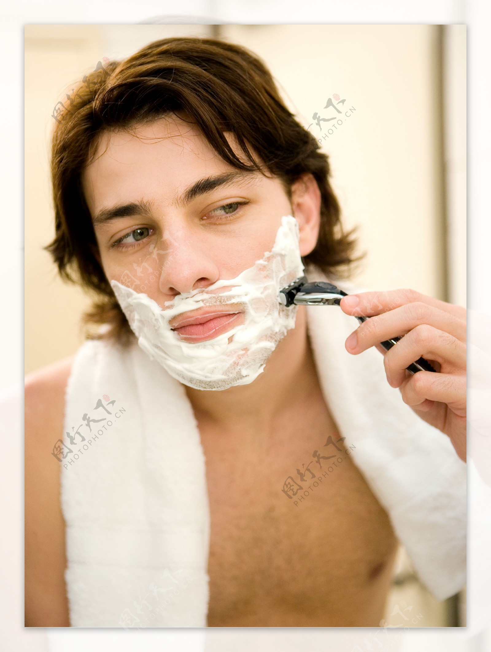 拿着剃须刀刮胡须的男人图片