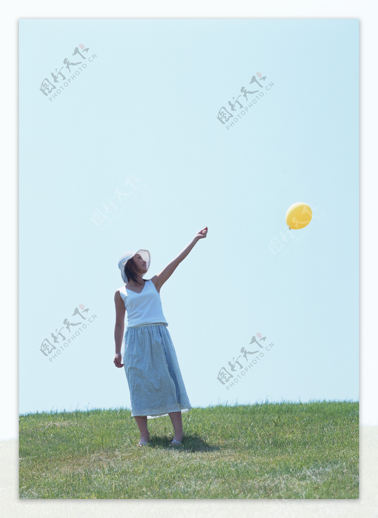 草地上玩气球的美女图片