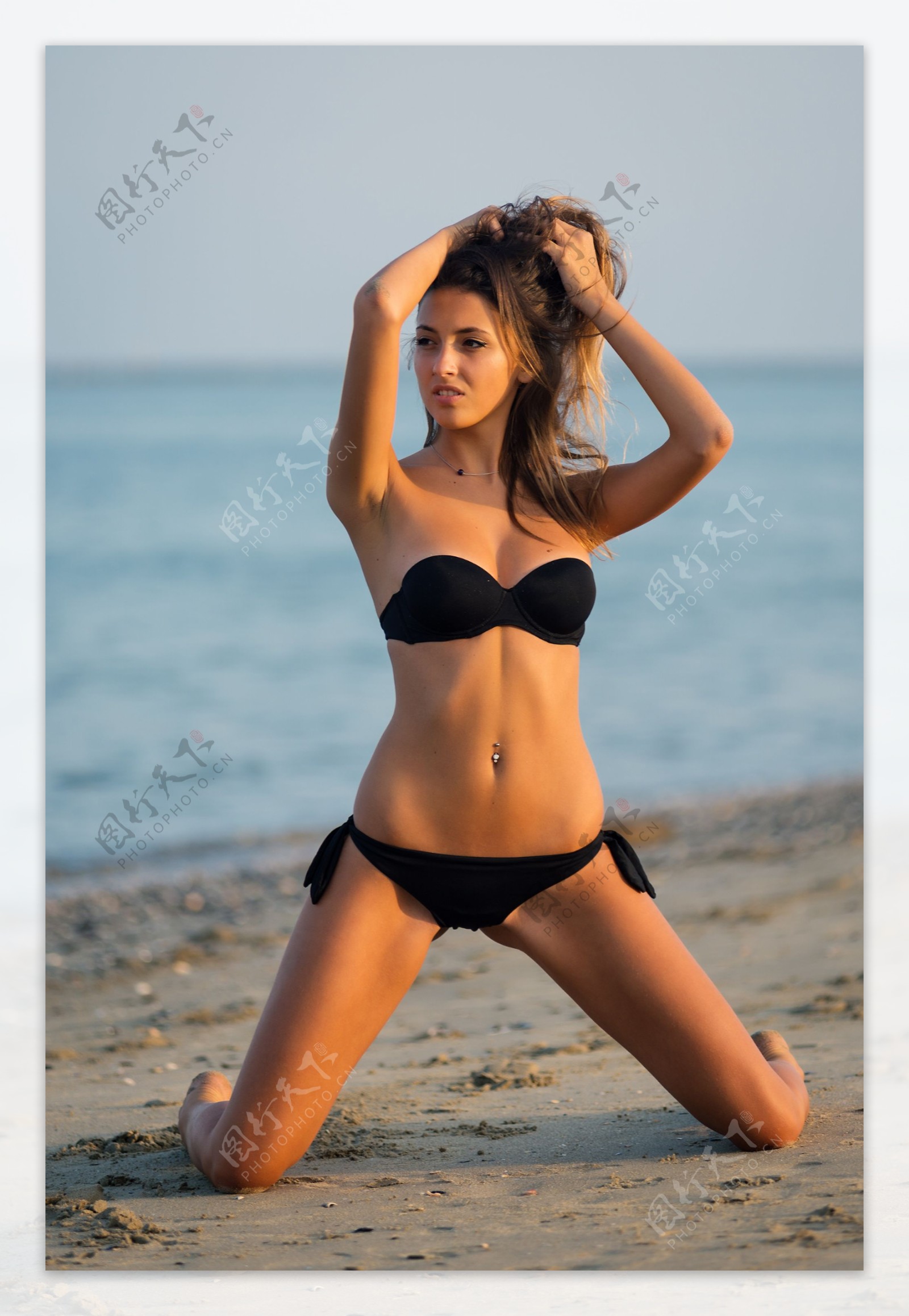 跪在沙滩上的泳装女人图片