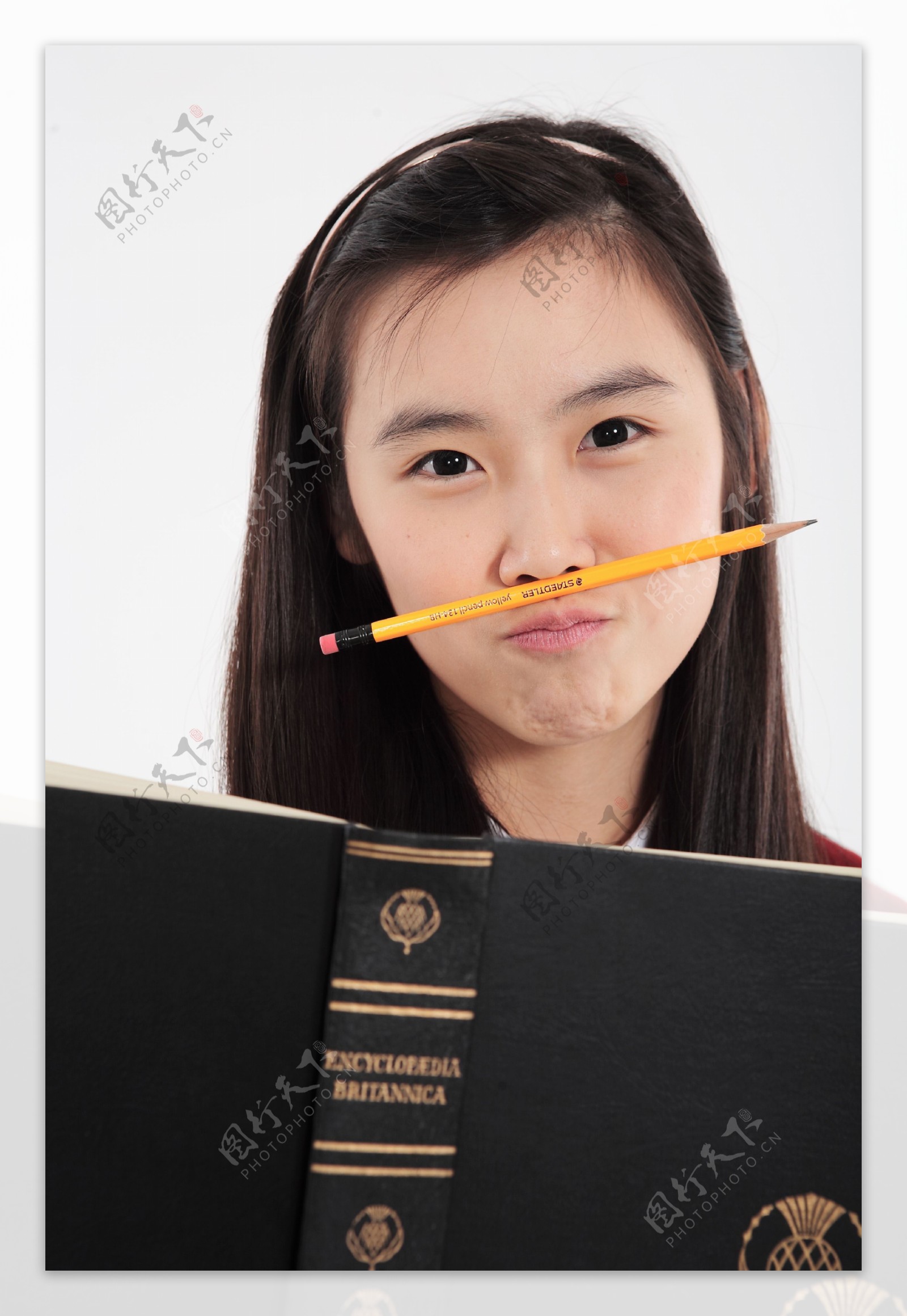 捧着书鼻子夹着铅笔的大眼睛女孩图片图片