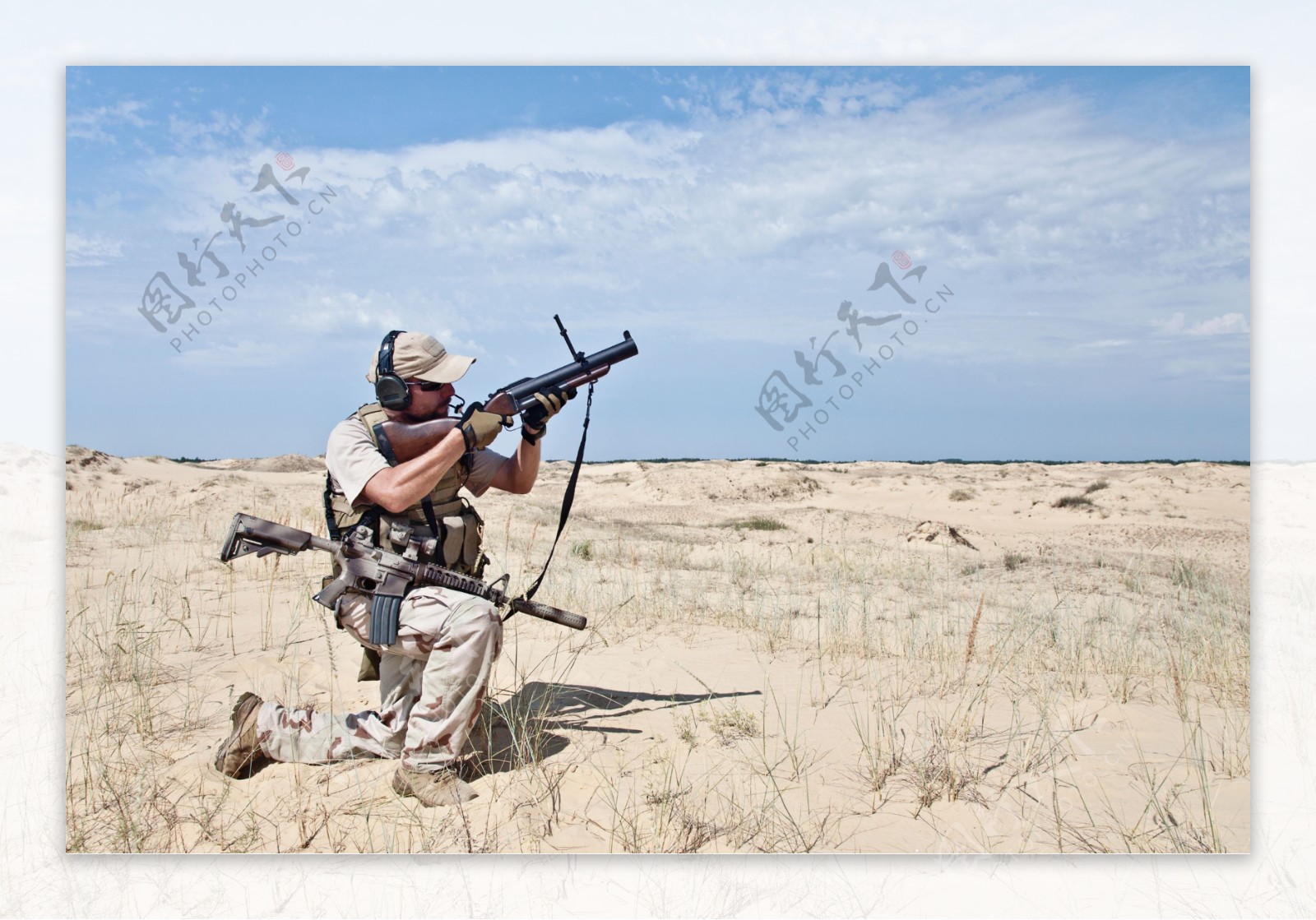 沙漠中拿着枪的男人图片