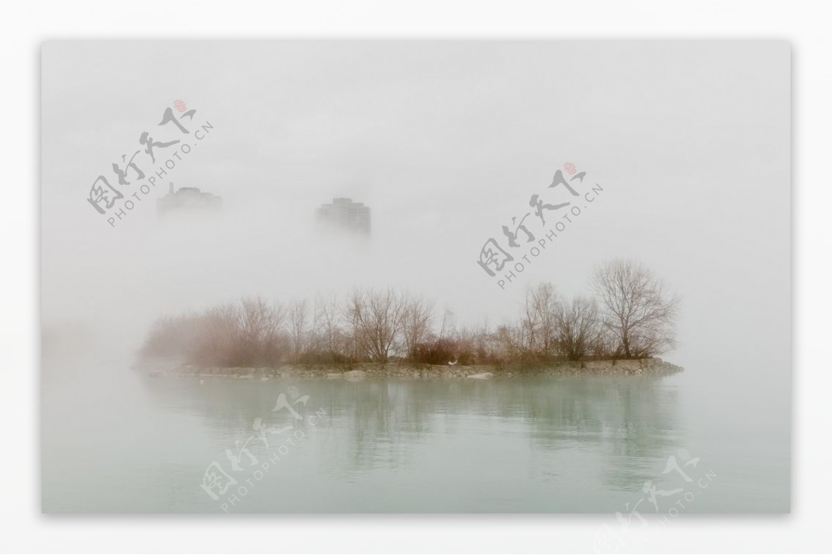 雾笼罩城市水边照片
